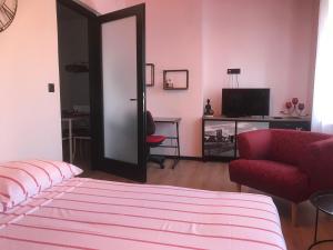a living room with a bed and a red chair at Apartments Colors of Rijeka - Red in Rijeka