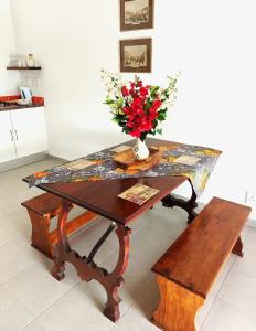 une table avec un vase de fleurs et un banc dans l'établissement Starry Rose Guest Farm, 