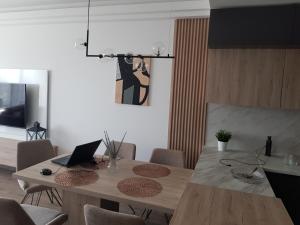 ein Esszimmer mit einem Tisch und einem Laptop darauf in der Unterkunft High Apartment in Skopje