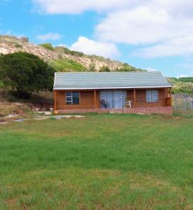 una pequeña casa en un campo al lado de una colina en Starry Rose Guest Farm, 