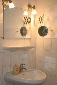 a white bathroom with a sink and a mirror at Wohnung-Schwalbennest in Süderende