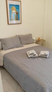 a bed with two towels on top of it at Emotion Apartments in Asprovalta