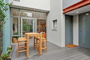 Un patio con una mesa y sillas de madera. en The Richmond House by Ready Set Stay, en Melbourne