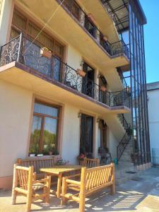 - un bâtiment avec 2 bancs en bois et un balcon dans l'établissement Sunrise - Guest House, à Anaklia