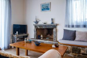 a living room with a couch and a fireplace at DP Homes Paros in Angairiá
