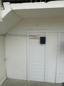 two white garage doors with a speaker on top at Storfossen Hostel in Gratangen