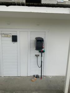 a parking lot with a pay phone in front of a garage at Storfossen Hostel in Gratangen