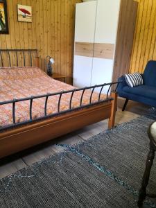 1 dormitorio con 1 cama y 1 silla azul en Studio with free parking Nice terrace Free WiFi connection en Ginebra