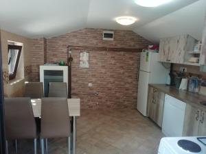a kitchen with a dining table and a brick wall at PAJO in Sutomore