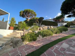einen Garten mit Felsen und Bäumen und einem Gehweg in der Unterkunft apartament close to beach in Cabrils