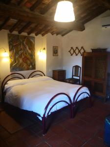 een slaapkamer met een groot wit bed in een kamer bij L'Orto dei Bruchi in Collodi
