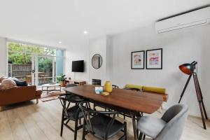 Una sala de estar con una mesa y sillas de madera. en The Richmond House by Ready Set Stay, en Melbourne