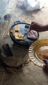 Spot Jaguar Pantanal South Lodgen في كورومبا: الشخص يقوم بطهي الطعام على شواية