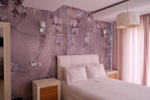 1 dormitorio con cama blanca y pared morada en Jnane Yemma en Tánger