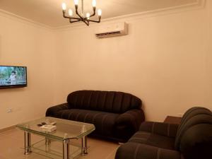 a living room with a leather couch and a table at Sedrah Hotel in Irbid