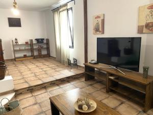 a living room with a large flat screen tv at Casa Del Amigo Carmelo in Ye