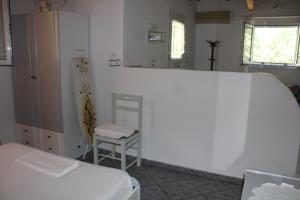 una camera con due letti, uno specchio e una sedia di Anastasia Apartments a Kámpos