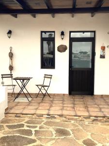 a patio with a table and chairs and a door at Casa Del Amigo Carmelo in Ye