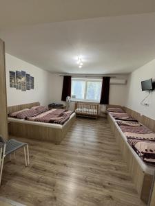 a room with three beds and a window at SUNNY Apartman in Štúrovo