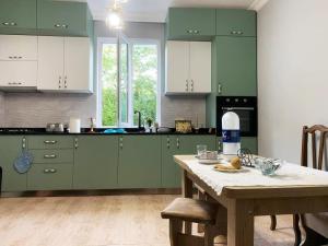 a kitchen with green cabinets and a wooden table at Nargizi guest house in Gonio