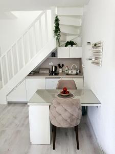 a white kitchen with a table and a chair at Apartman DANA in Banja Luka
