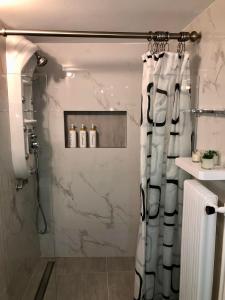 a shower with a shower curtain in a bathroom at SYRIOS House & Apartments in Nafplio