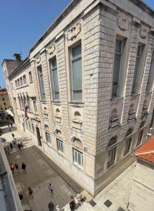 a large brick building with people walking in front of it at Zadar Enjoy Apartment in Zadar