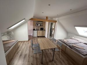 a room with a table and chairs and a bedroom at SUNNY Apartman in Štúrovo