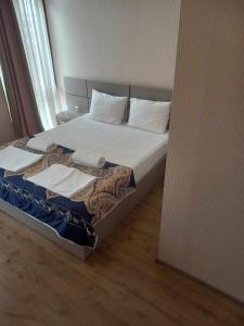 - une chambre avec un lit doté de draps et d'oreillers blancs dans l'établissement Sunrise - Guest House, à Anaklia