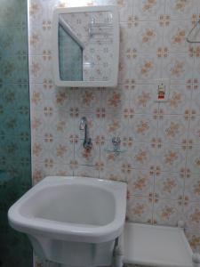 a bathroom with a sink and a mirror on the wall at Lindo Studio na Praia do Gonzaguinha II in São Vicente