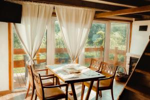 comedor con mesa, sillas y ventana en Beneháti kunyhók, en Mátrafüred