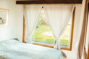 a bedroom with a bed and a window at Beneháti kunyhók in Matrafured