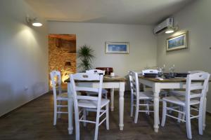 uma sala de jantar com uma mesa branca e cadeiras em matana b&b em Carmignano