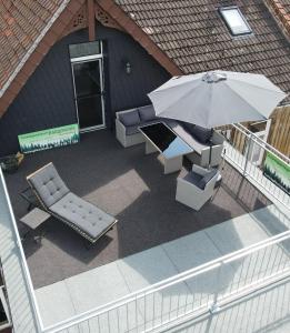 una vista aérea de un patio con sombrilla y sillas en HAR(z)MONIE Penthouse in Blankenburg, en Blankenburg