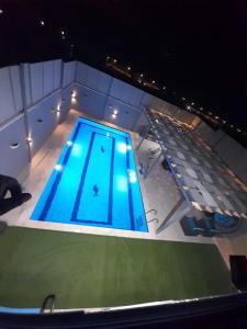 an overhead view of a swimming pool at night at Barcode Chalet in Ash Shāghūr