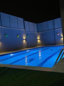 a swimming pool at night with lights on it at Barcode Chalet in Ash Shāghūr