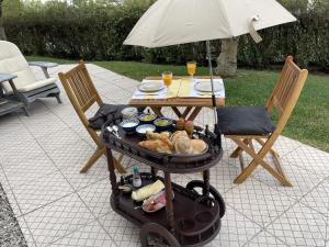 a table with food on a grill with an umbrella at Casas Cerejas in Serra de Mangues