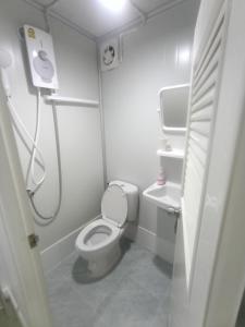 a small bathroom with a toilet and a sink at PA House Apartment in Bangkok