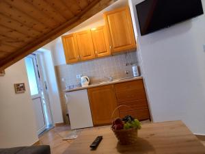 a kitchen with a table with a bowl of fruit on it at Studio apartman Ivana in Jajce