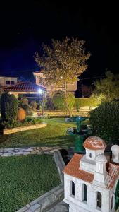 a garden at night with a fountain in the yard at Anemos Pelion Seaview in Kala Nera