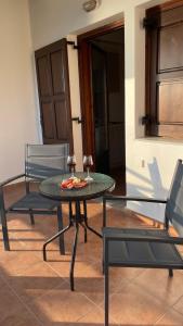 a table with two chairs and a table with a pizza on it at Anemos Pelion Seaview in Kala Nera