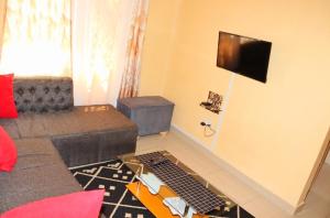a living room with a couch and a tv at FLORENCE APARTMENTS A in Mtwapa