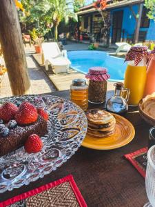 a table with a plate of pancakes and strawberries at Recanto Zen Praia do Rosa in Praia do Rosa