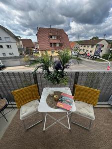 a balcony with a table and chairs on a balcony at Komfortables, barrierefreies Appartement mit sonnigem Balkon in der Nähe von Flughafen und Messe 30 in Leinfelden-Echterdingen +13 photos