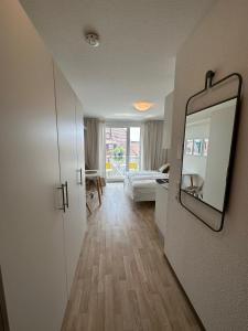 a hallway with a mirror and a living room at Komfortables, barrierefreies Appartement mit sonnigem Balkon in der Nähe von Flughafen und Messe 30 in Leinfelden-Echterdingen