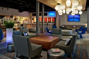 a lobby with chairs and a table and a bar at Aloft Hotel Calgary University in Calgary