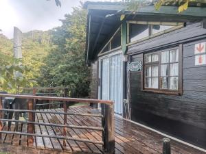 een houten terras met een gebouw met een deur bij Amapondo Backpackers Lodge in Port St Johns