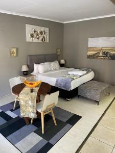 a bedroom with a bed and a table and chairs at Menlyn Mews Guesthouse in Pretoria