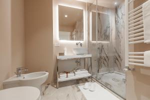 y baño con ducha, lavabo y aseo. en Dei Priori Boutique Hotel en Assisi