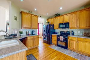 eine Küche mit Holzschränken und einem schwarzen Kühlschrank in der Unterkunft Its Always Sunny in Sykesville Full Property in Sykesville